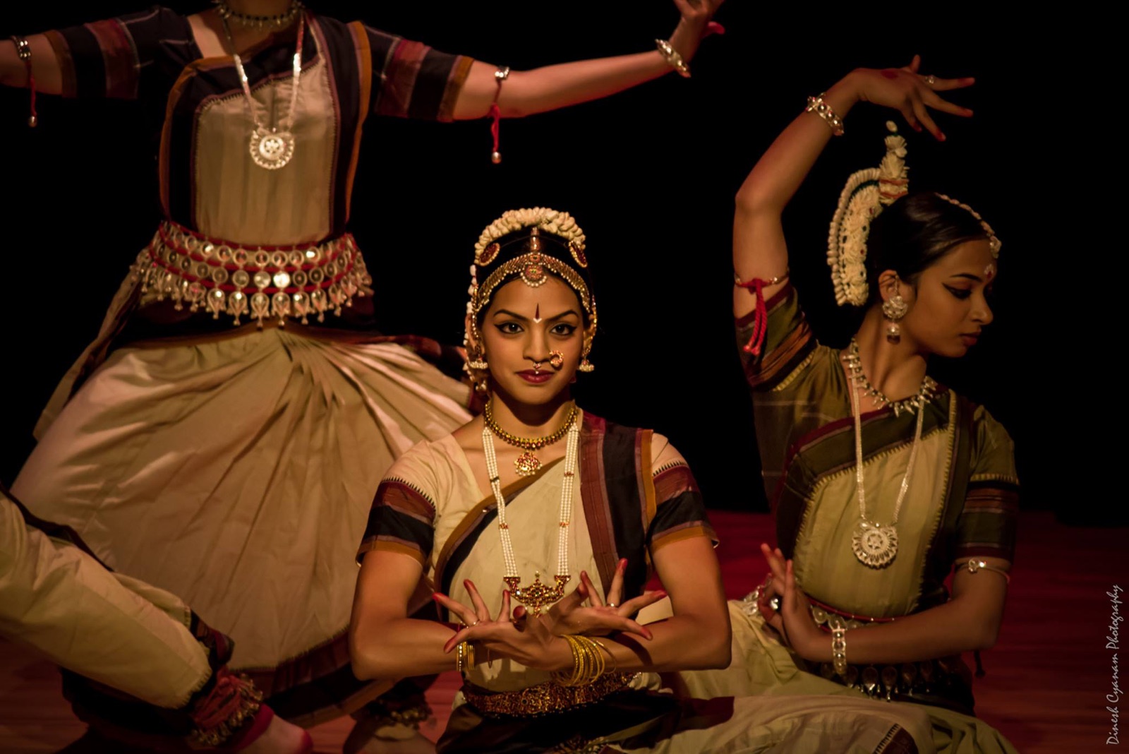 Vertika performing bharatanatyam on stage with an ensemble, in cream and maroon costumes with traditional jewelry.